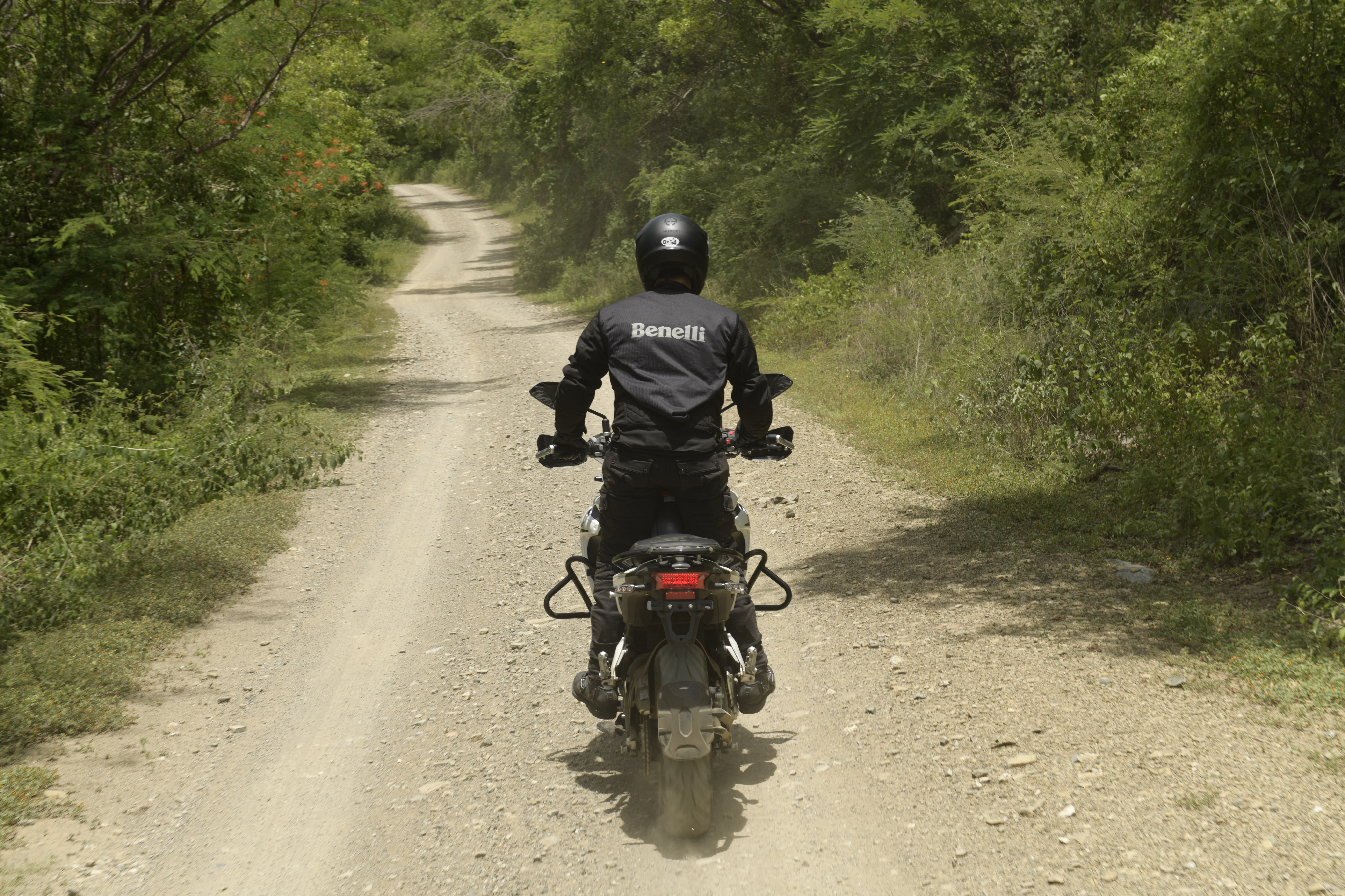 Piloto con equipo de seguridad completo rodando en terracer&iacute;a en la Benelli TRK 502.