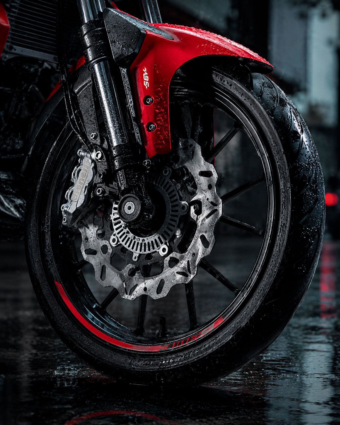 Detalle de la llanta delantera y sistema de freno de una Benelli 302S roja, mojados por la lluvia sobre pavimento húmedo.